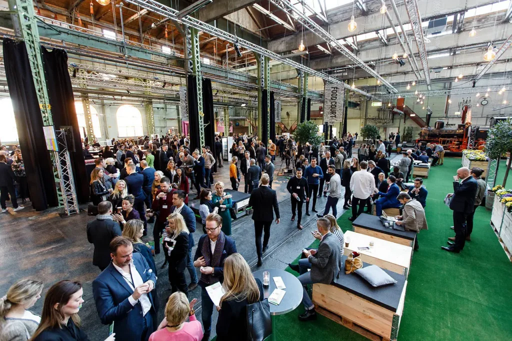 Asistentes conversan, hacen networking y sostienen conversaciones en un gran salón de eventos durante Future Product Days